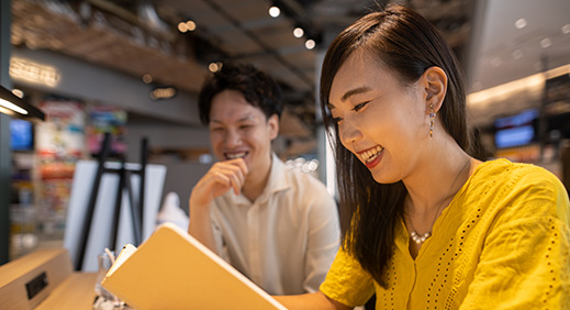 Portrait of young smiling woman looking at camera with crossed arms. Happy girl standing in creative office. Successful businesswoman standing in office with copy space.