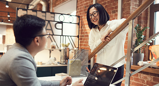 Young african man looking at his girlfriend using credit card and smartphone for shopping online in cafe
