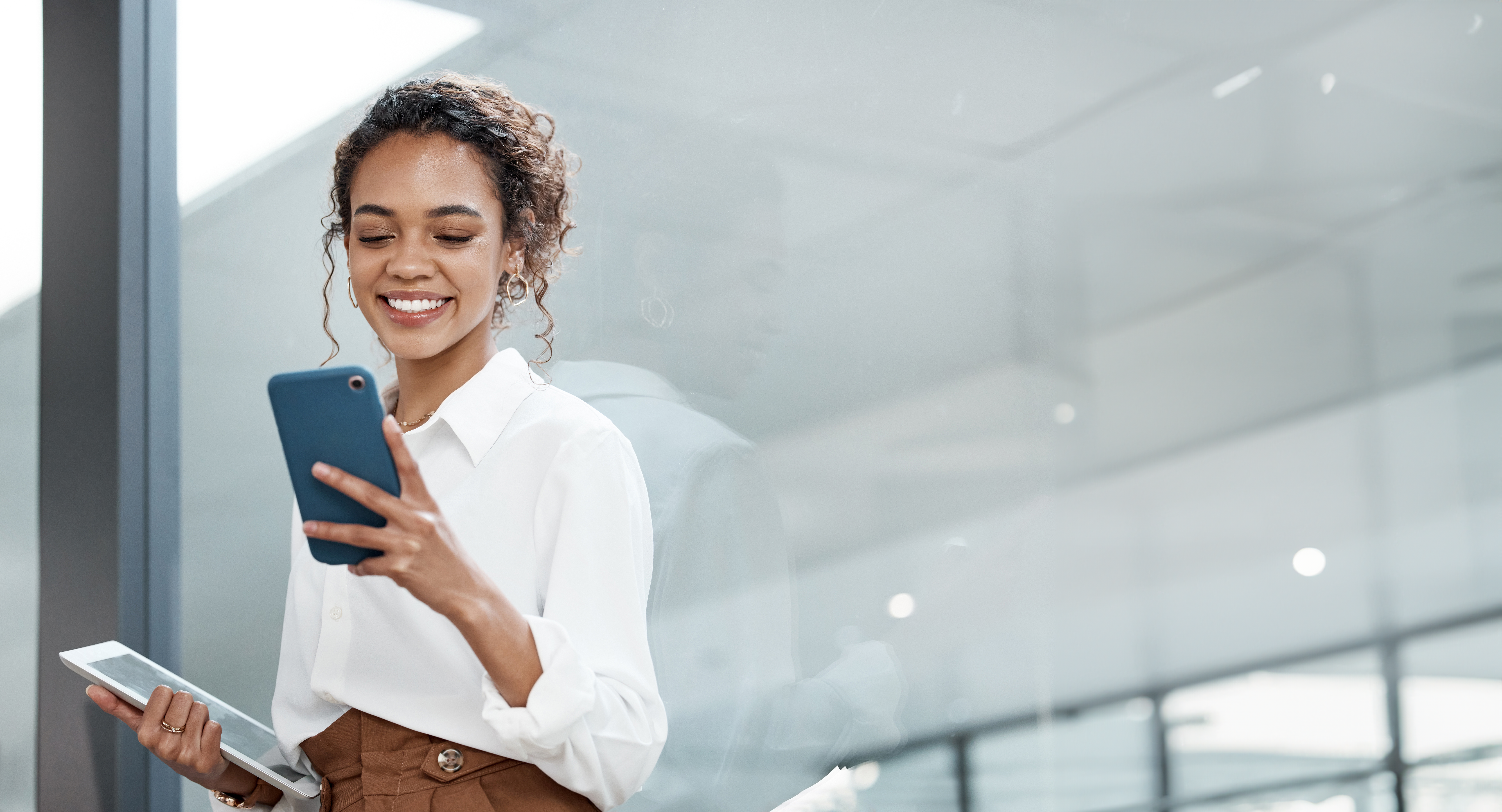 Young African-American woman looking successful while on her phone in an office setting