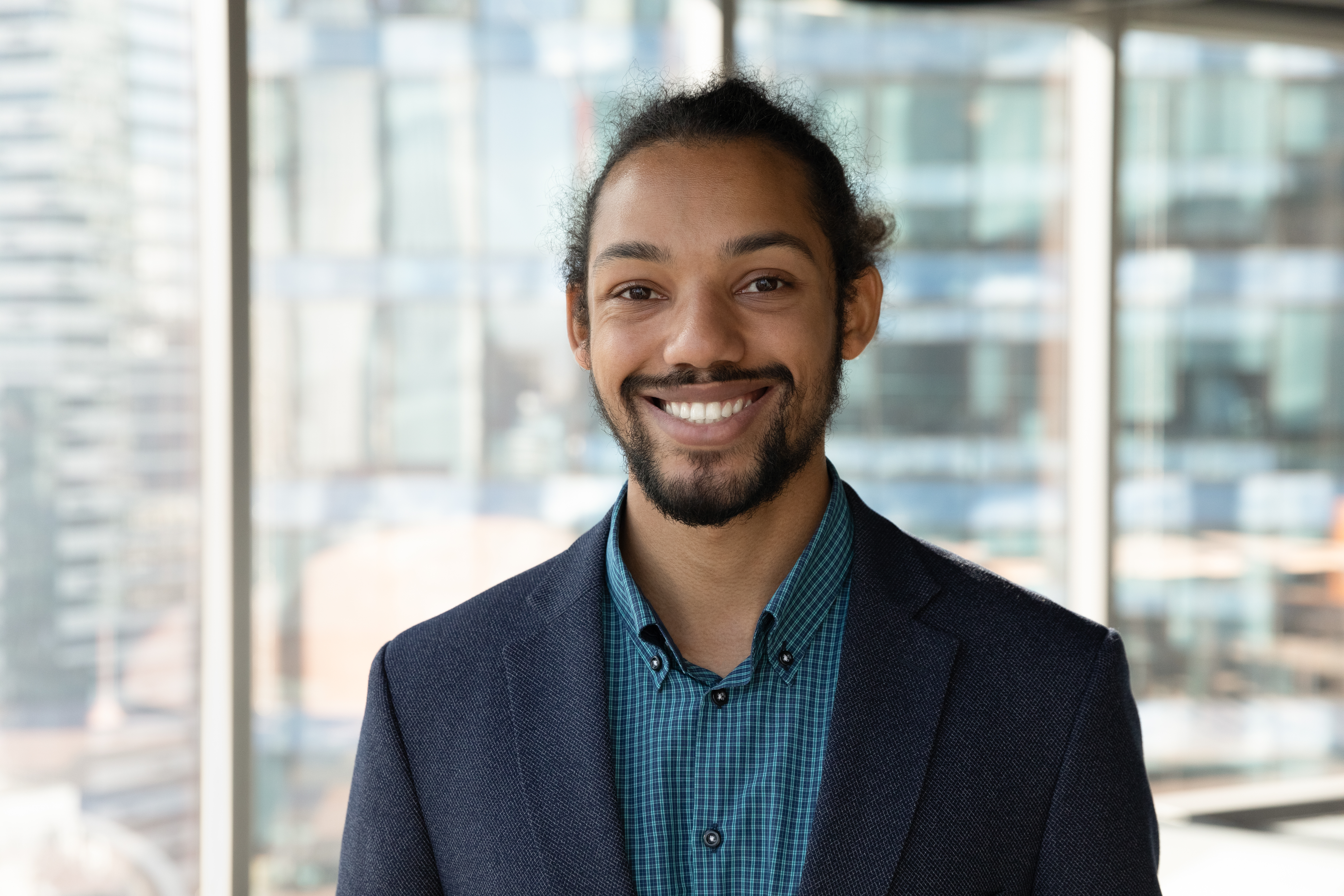 Headshot portrait of smiling young African American businessman in suit pose in own modern office. Profile picture of happy successful male boss or CEO in formalwear show confidence and leadership.