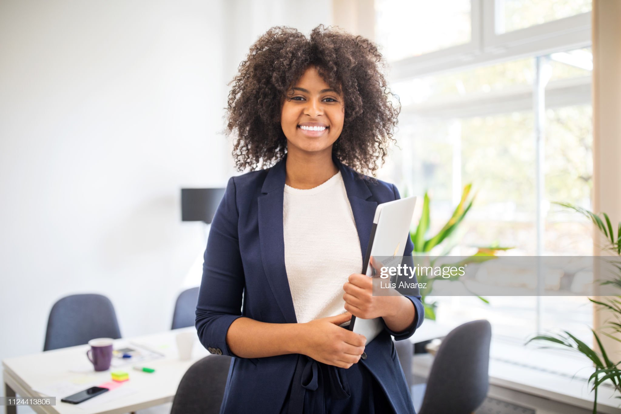 Headshot portrait of smiling young African American businessman in suit pose in own modern office. Profile picture of happy successful male boss or CEO in formalwear show confidence and leadership.