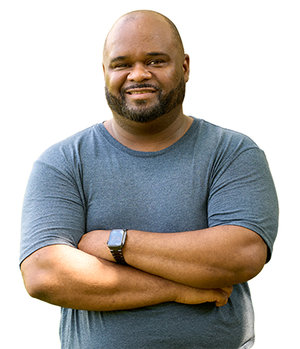 Wounded warrior Chris Gordon smiles with his arms crossed while wearing a gray shirt and a smart watch on his left wrist.