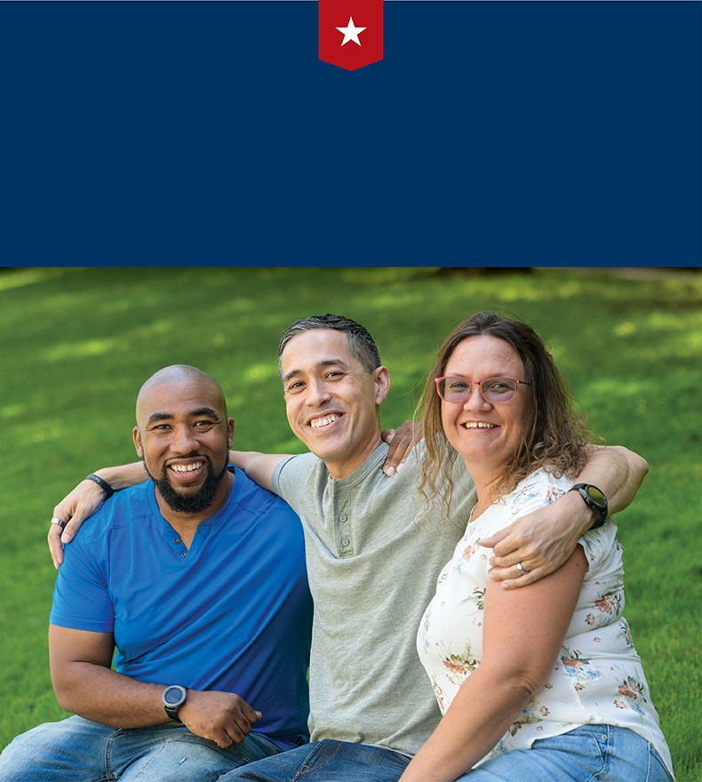 Wounded warriors Michael Powell, Sergio Alfaro, and Nicole Shorter sit atop a brick wall and smile for a group photo.